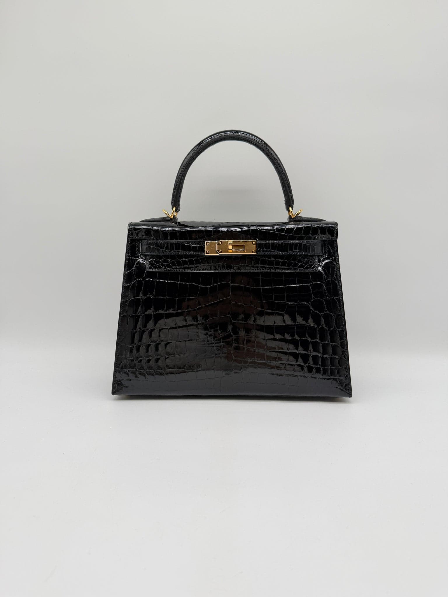 Hermès Kelly 28 in Noir Shiny Niloticus Gold (GHW) hardware — front view