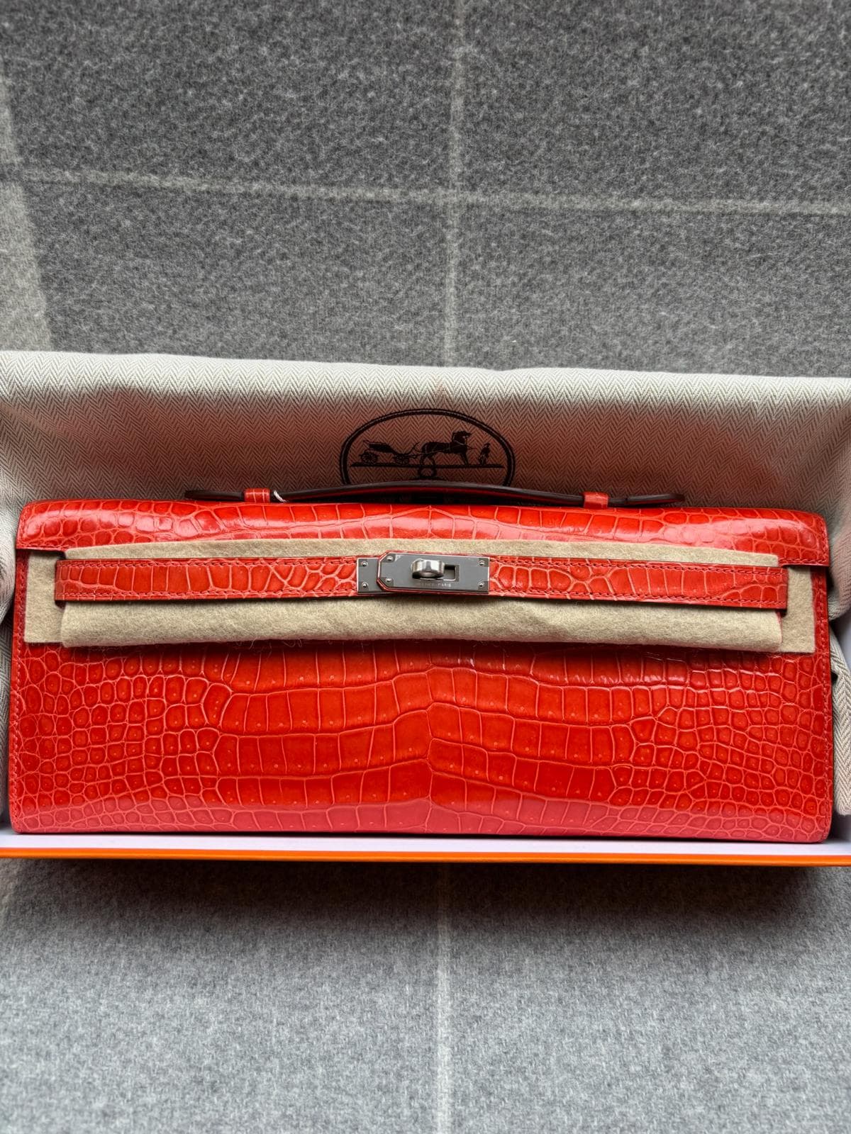 Hermès Kelly Cut in Orange Poppy Porosus Shiny PHW hardware — front view